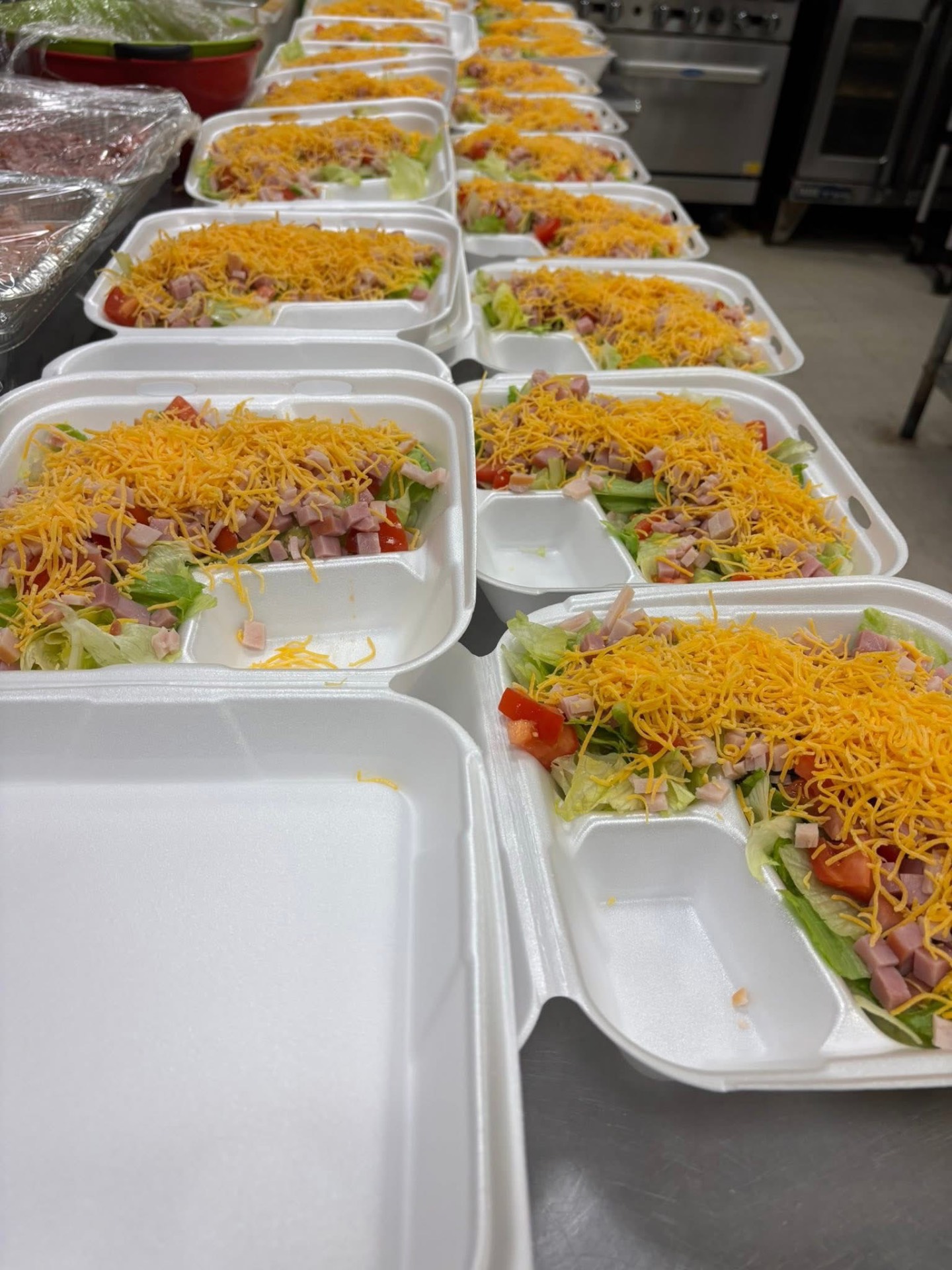 Rows of styrofoam containers filled with chef salads