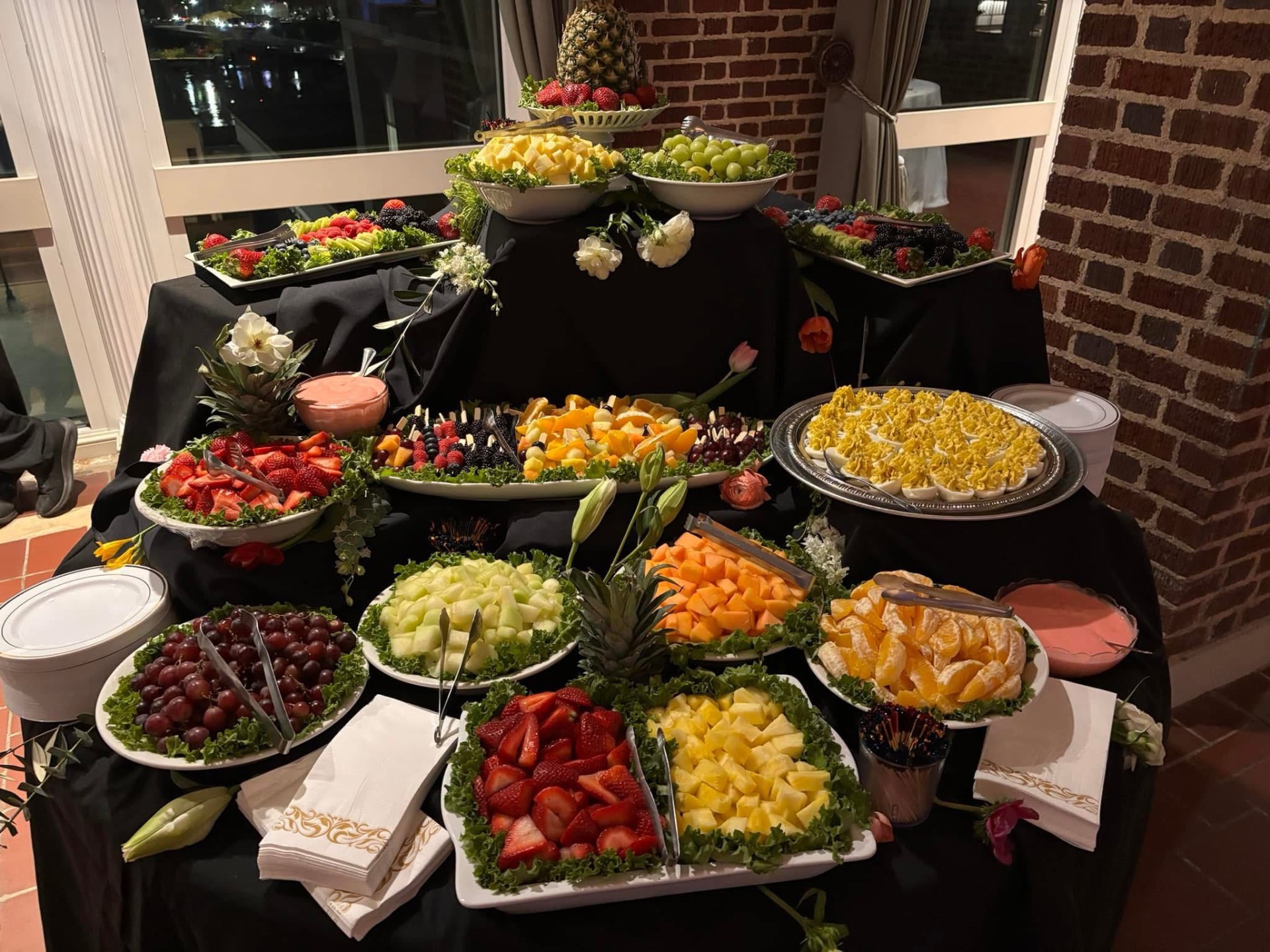 Elaborate fruit and deviled egg display on black linens