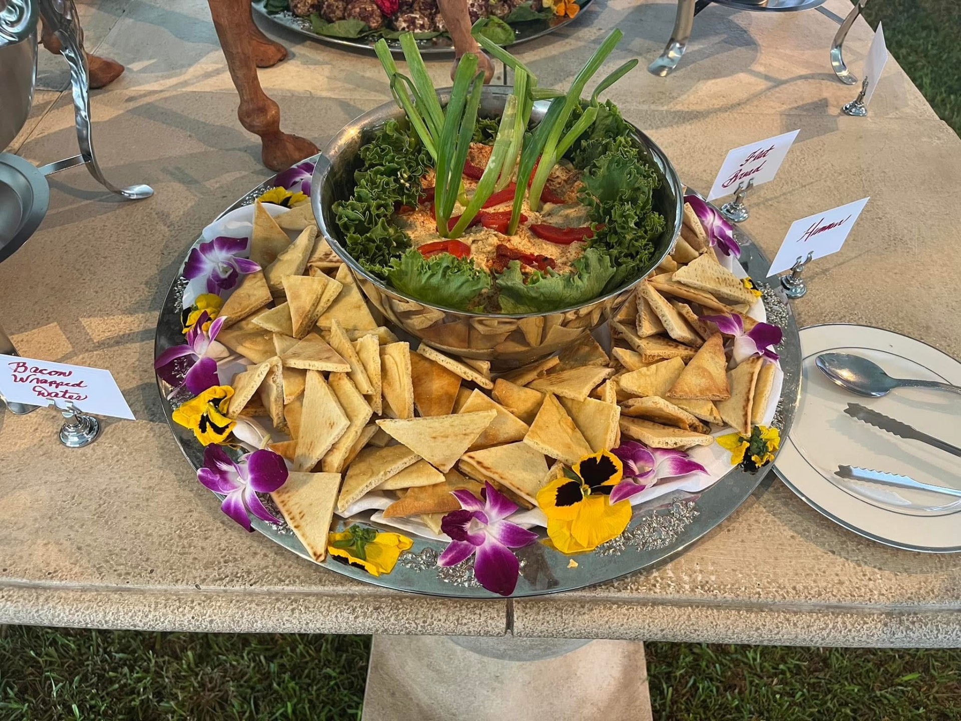 Silver platter of hummus and pita points